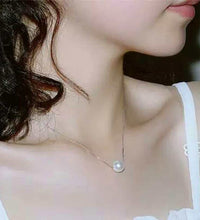 Woman wearing faux pearl clavicle necklace at collarbone
