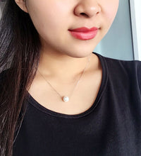 Woman wearing faux pearl clavicle necklace at collarbone

