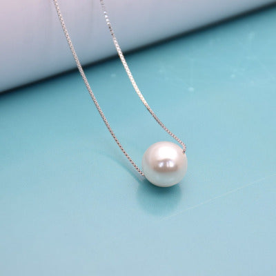 Woman wearing faux pearl clavicle necklace at collarbone
