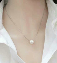 Woman wearing faux pearl clavicle necklace at collarbone

