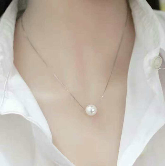 Woman wearing faux pearl clavicle necklace at collarbone
